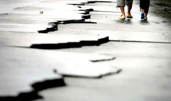 Отец и сын идут возле трещины, которая образовалась от землетрясения в Японии