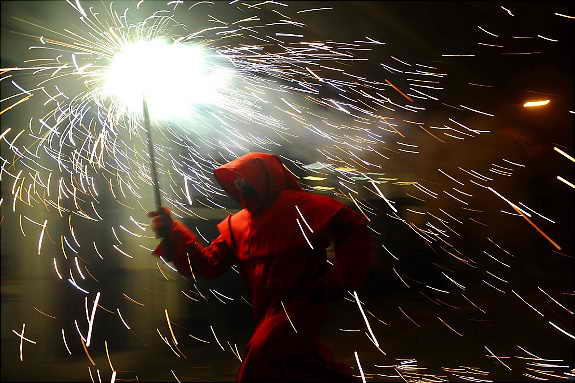 Участник испанского праздника "Бега с огнем" ("Correfoc") бежит с факелом по Барселоне