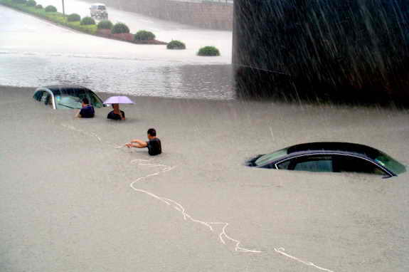 Две машины ушли под воду во время наводнения в городе Венцу, Китай
