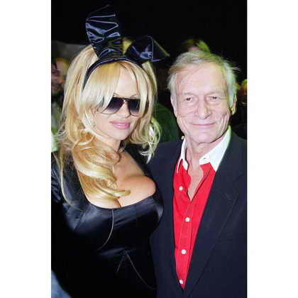 Основатель и издатель Playboy Хью Хефнер и бывшая модель Playboy Памела Андерсон позируют на 50-летии журнала Playboy в Нью Йорке в 2003 году