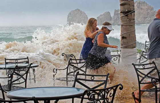 Люди убегают от огромной волны, которая накрыла берег пляжа Медано в Мексике во время урагана Рик, обрушившегося на популярное место отдыха Баджа Калифорния.