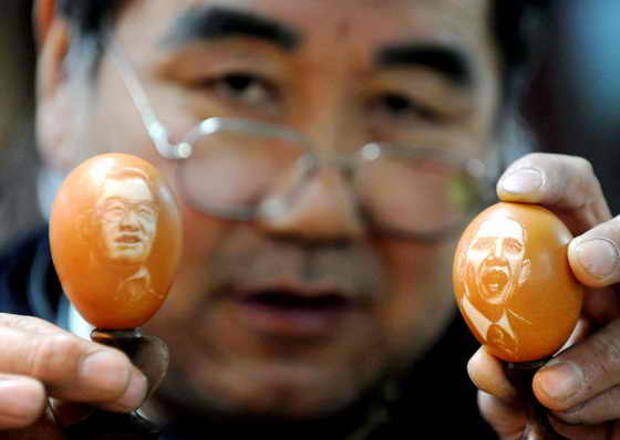 Китайский художник Kang Yongguo показывает портреты президента США Барак Обама и китайского президента Ху Цзиньтао, которые он сделал на обычных куриных яйцах