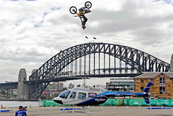 Американец Трэвис Пастрана (Travis Pastrana) совершил невероятный прыжок на мотоцикле через вертолет на высоту 13 метров на фоне Сиднейского моста Sydney Harbour Bridge