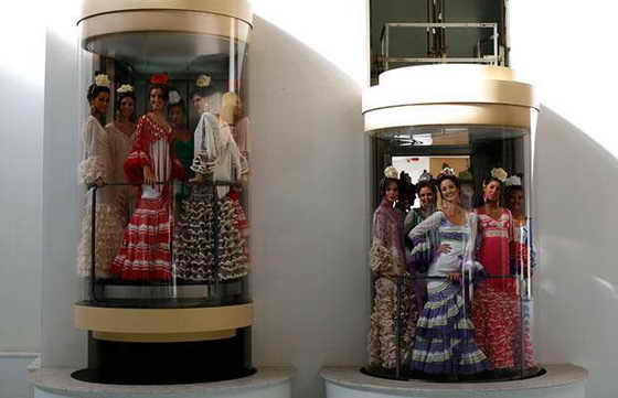 Конкурсантки Мисс Севилья, одетые в традиционные севильские платья, позируют в лифтах в столица Андалузии Севильи