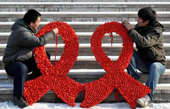 Студенты делают большие красные ленты на улице во время акции о поднятии осведомленности о ВИЧ / СПИДе во Всемирный день борьбы со СПИДом в Шеньян, провинция Ляонин, Китай