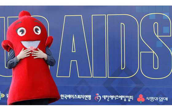Работника, одетый в красную форму-презерватив приобщает к использованию презервативов во время кампаний, поднимающей сознательность и осведомленность о СПИДе в Сеуле, Южная Корея