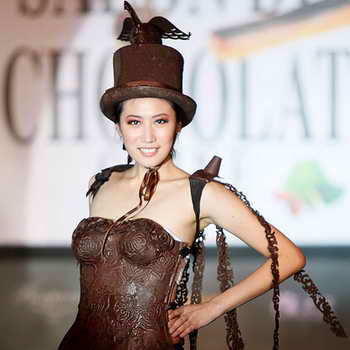 Модель идет в шоколадном платье и цилиндре на модном шоколадном шоу Salon du Chocolat в Шанхае, Китай