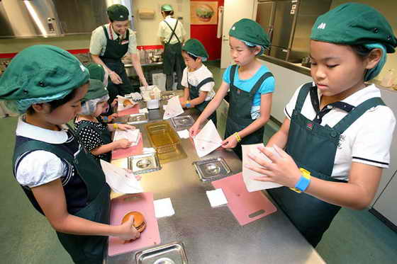Дети играют в мастеров-кулинаров по изготовлению гамбургеров