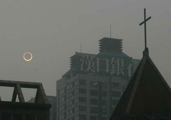 Луна проходит между Солнцем и Землей во время кольцевого солнечного затмения в городе Чунцин, Китай